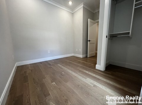 A room with wooden flooring and white walls.