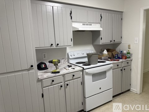 A kitchen with white cabinets and appliances is undergoing renovation.