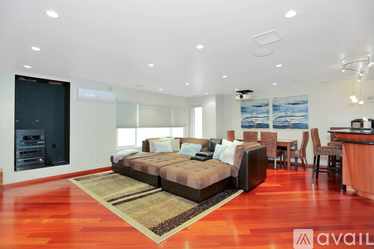 A modern living room with a brown sofa and a wooden floor.