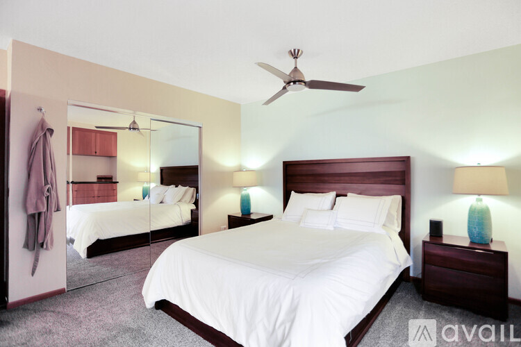 A bedroom with a large bed and a mirror on the wall.