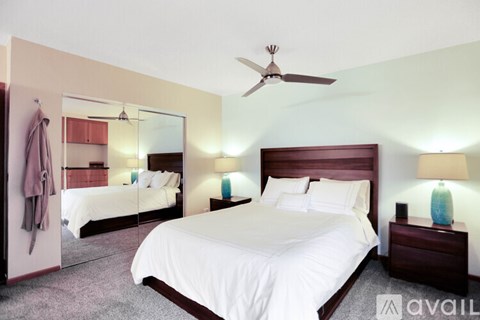 A bedroom with a large bed and a mirror on the wall.