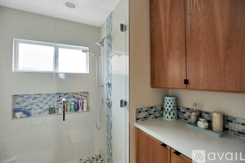 A bathroom with a shower and a sink.