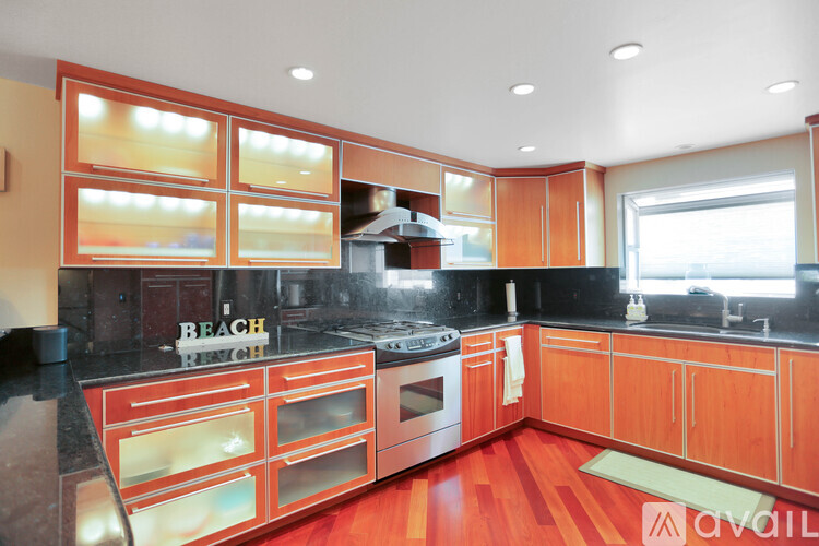 A kitchen with wooden cabinets and a black counter top.