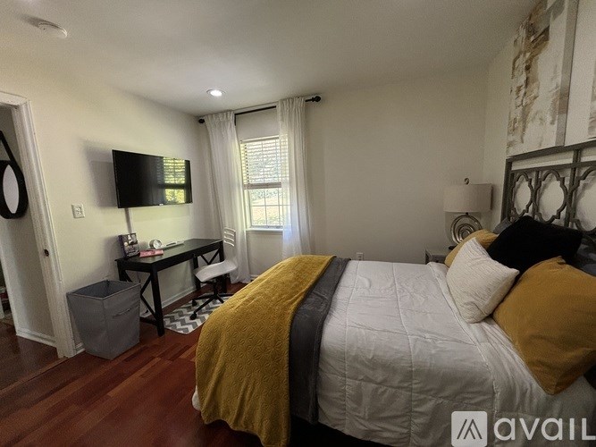 A bedroom with a bed, desk, and chair.