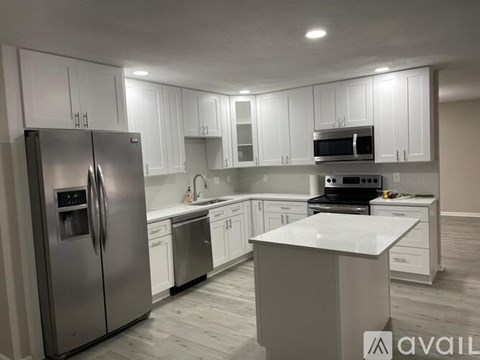 A kitchen with white cabinets and stainless steel appliances.