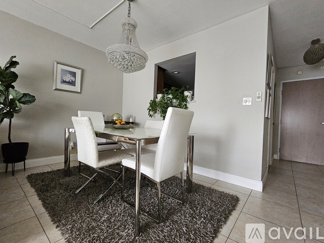 A dining room with a white table and chairs.