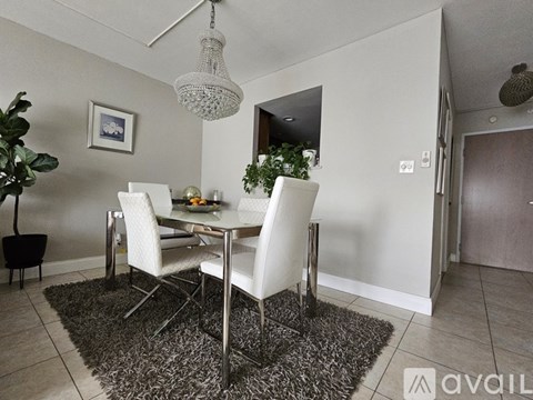 A dining room with a white table and chairs.