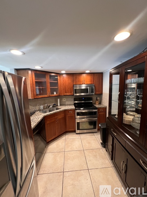 A kitchen with brown cabinets and a granite countertop.