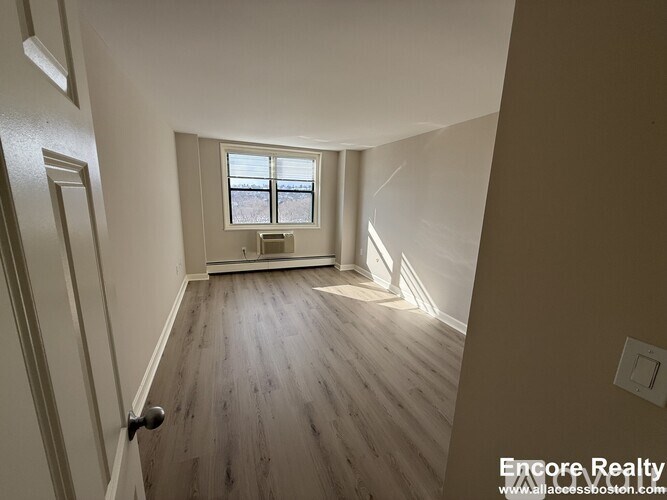 A room with wooden floors and a window.