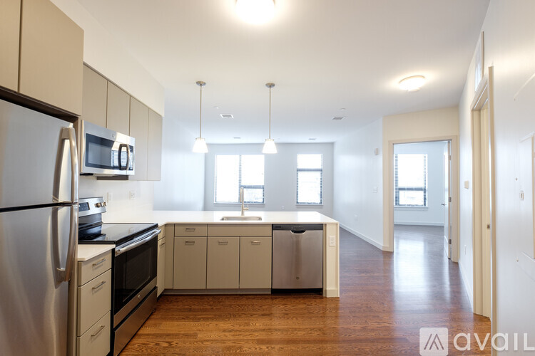 A kitchen with white cabinets and a stainless steel refrigerator.