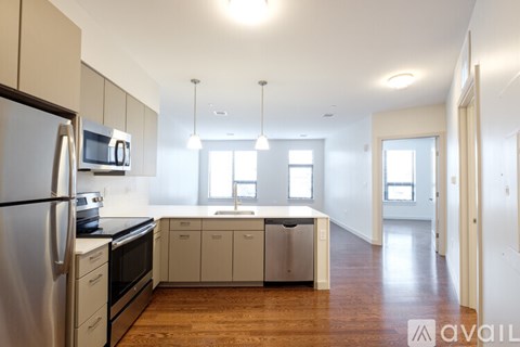 A kitchen with white cabinets and a stainless steel refrigerator.