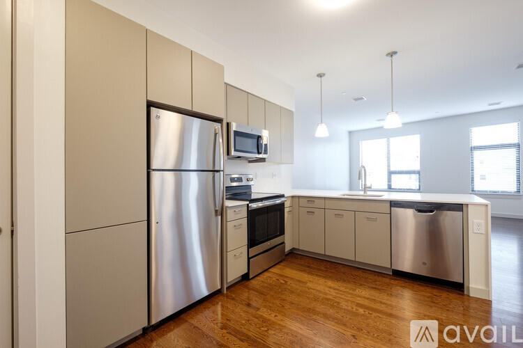 A kitchen with a stainless steel refrigerator and wooden floors.