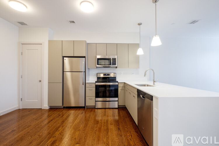 A kitchen with wooden floors and stainless steel appliances.