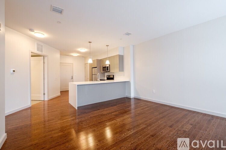 A spacious room with wooden floors and a white reception desk.