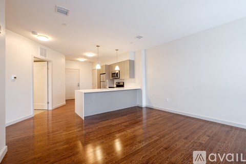 A spacious room with wooden floors and a white reception desk.