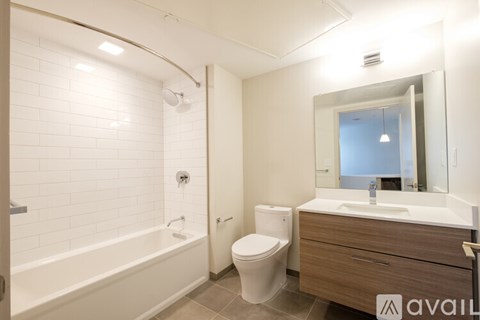 A bathroom with a white tub, toilet, and sink.