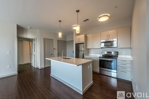 A modern kitchen with a center island and stainless steel appliances.
