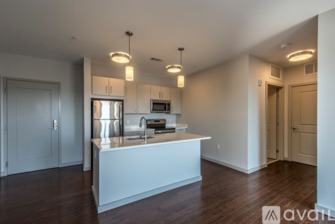 A modern kitchen with a white island and stainless steel appliances.