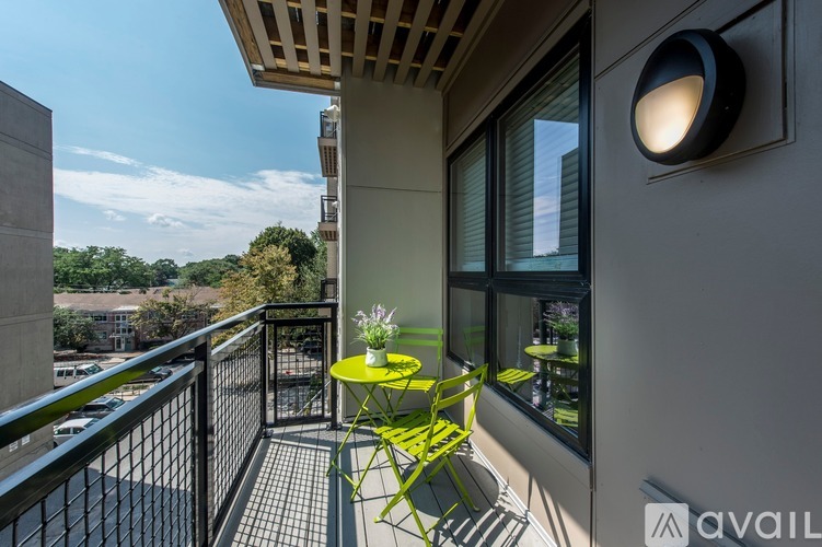 A balcony with a table and chairs overlooking a parking lot.