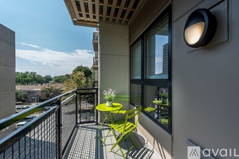 A balcony with a table and chairs overlooking a parking lot.