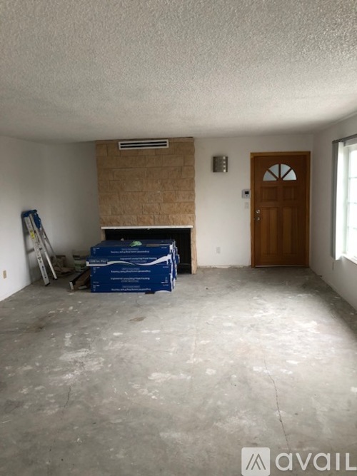 A room with a fireplace and a door is available for rent.