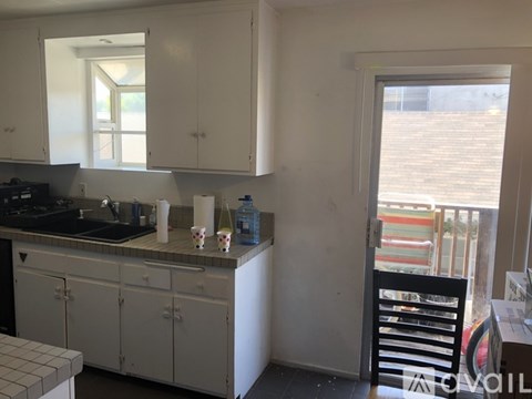 A kitchen with white cabinets and a black stove top.