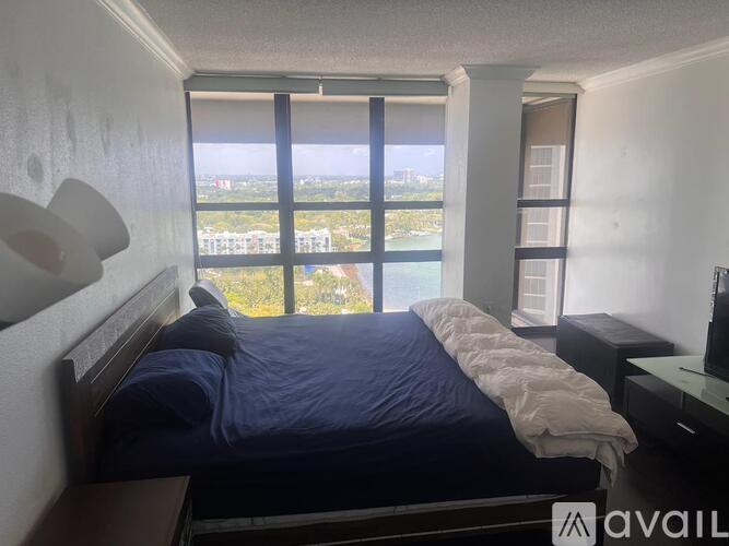 A bedroom with a large bed and a view of the city.