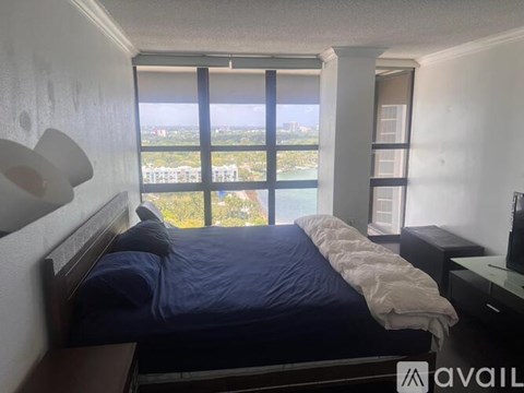 A bedroom with a large bed and a view of the city.
