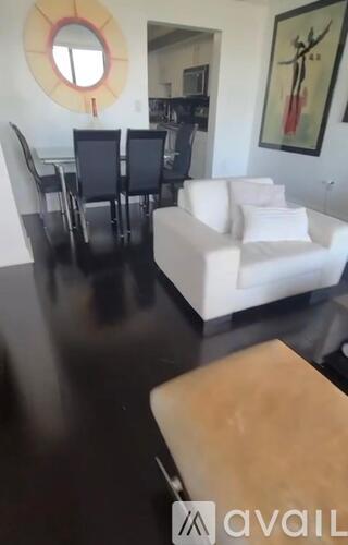 A living room with a white couch and a wooden coffee table.