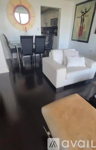 A living room with a white couch and a wooden coffee table.
