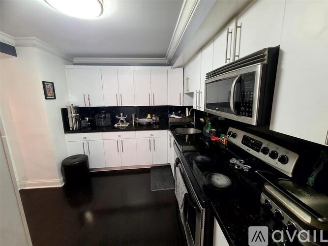 A kitchen with black countertops and white cabinets.