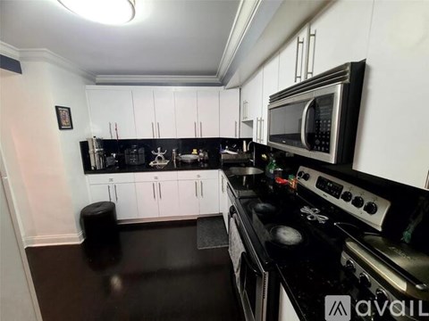 A kitchen with black countertops and white cabinets.