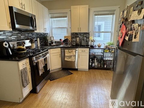 A kitchen with black countertops and white cabinets.