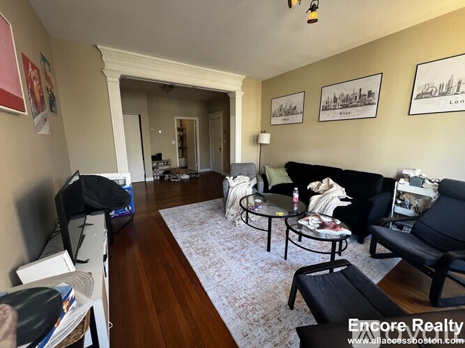 A living room with a black couch and a coffee table.