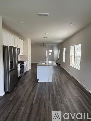 A kitchen with a refrigerator, microwave, and oven is available for rent.