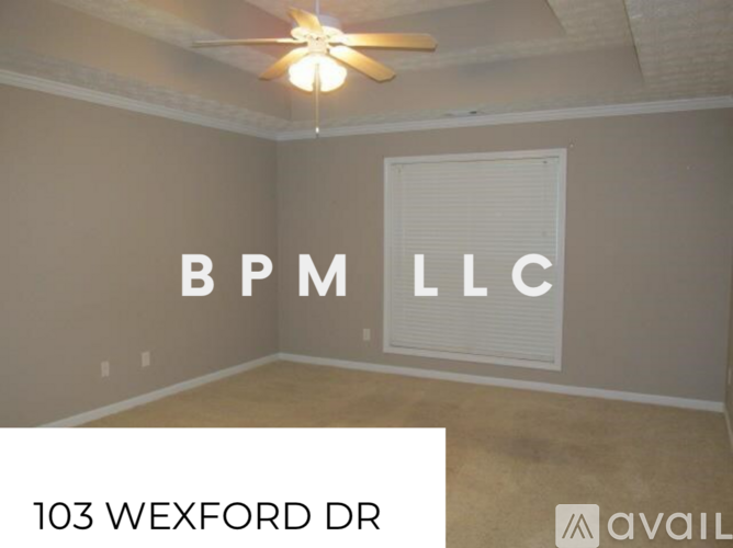 A room with a ceiling fan and a window with blinds, and a sign that says BPM LLC.