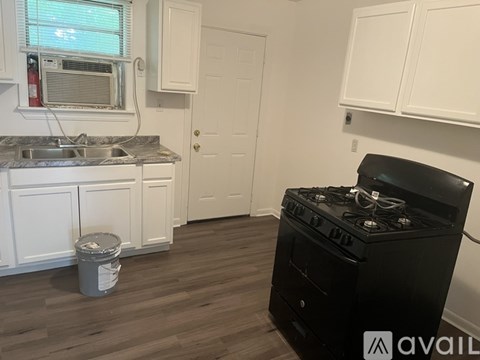 A kitchen with a black stove and white cabinets.