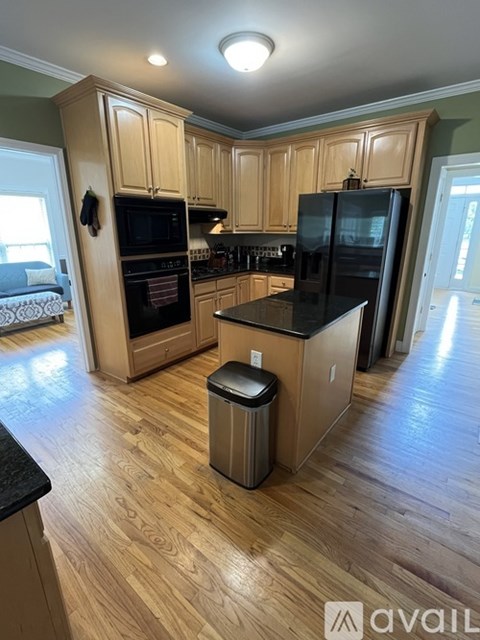 A kitchen with wooden cabinets and black countertops.