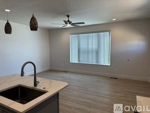A kitchen with a sink and a ceiling fan.