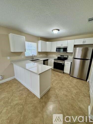 A kitchen with white cabinets and appliances.