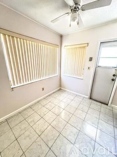 A room with a ceiling fan and tiled flooring.