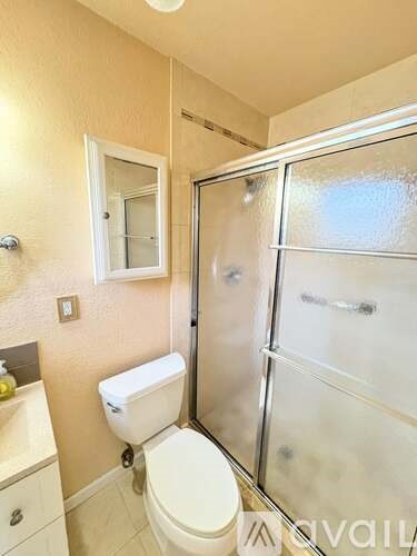 A bathroom with a toilet, sink, and shower.