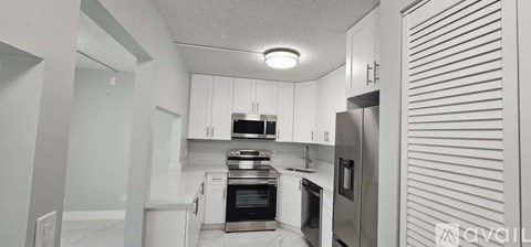 A kitchen with white cabinets and stainless steel appliances.