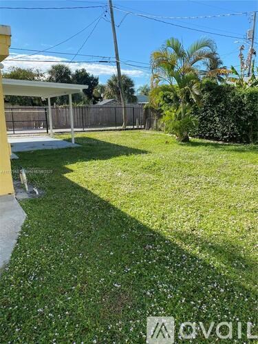 A backyard with a well-maintained lawn and a fence.