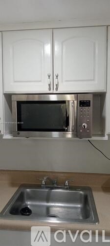 A kitchen with a microwave and a sink.