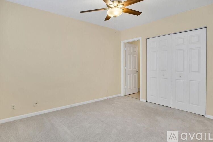 A room with a ceiling fan and two doors.