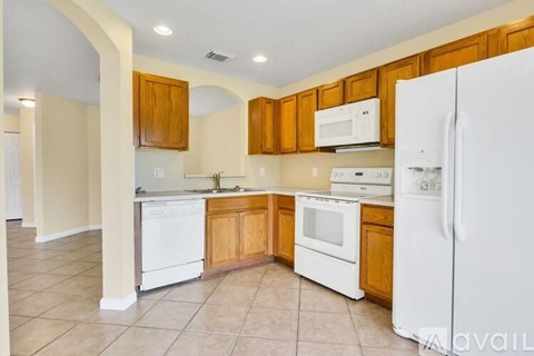 A kitchen with white appliances and wooden cabinets.