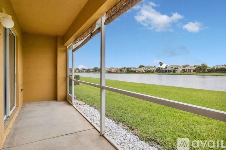 A balcony with a view of a grassy field and houses.