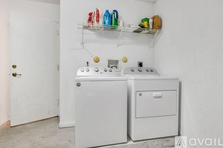 A white laundry room with a washer and dryer.
