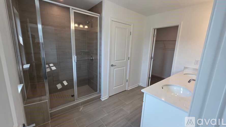 A bathroom with a sink, mirror, and shower.